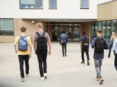 Adolescentes se dirigindo a entrada da escola